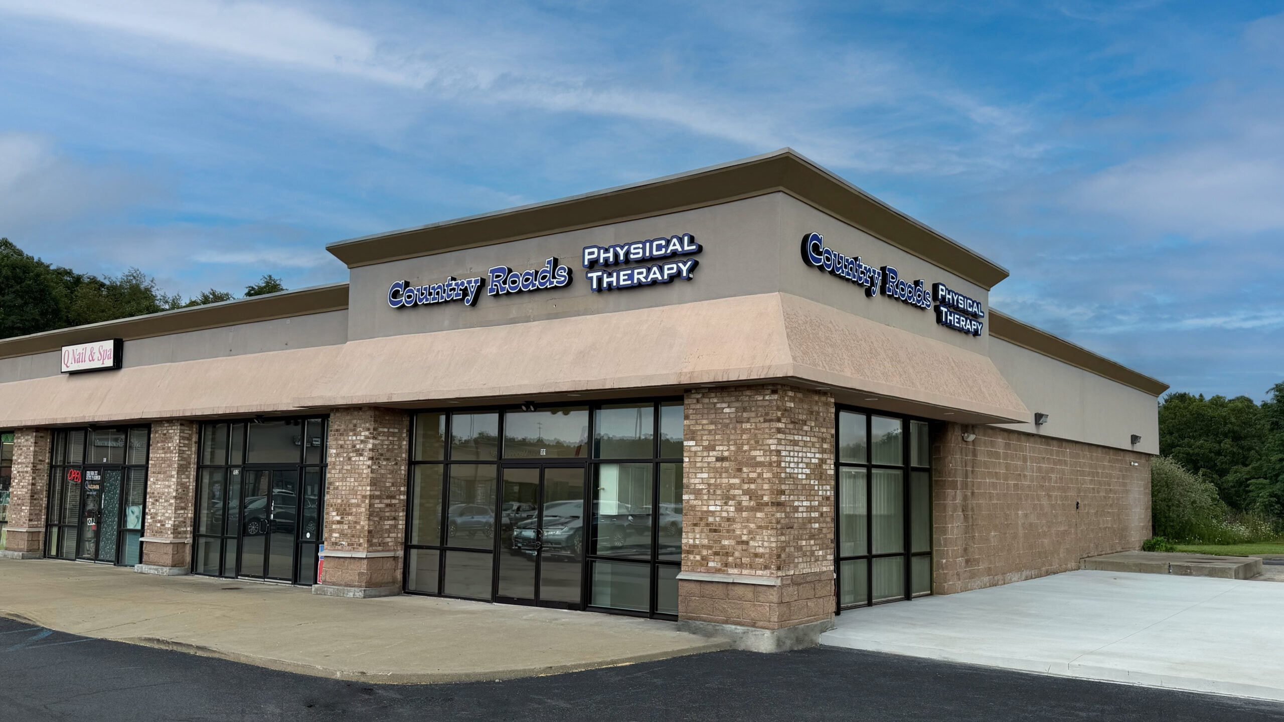 Exterior View of South Morgantown Country Roads Location, stone building with walls consisting of windows with a blue sky in the background